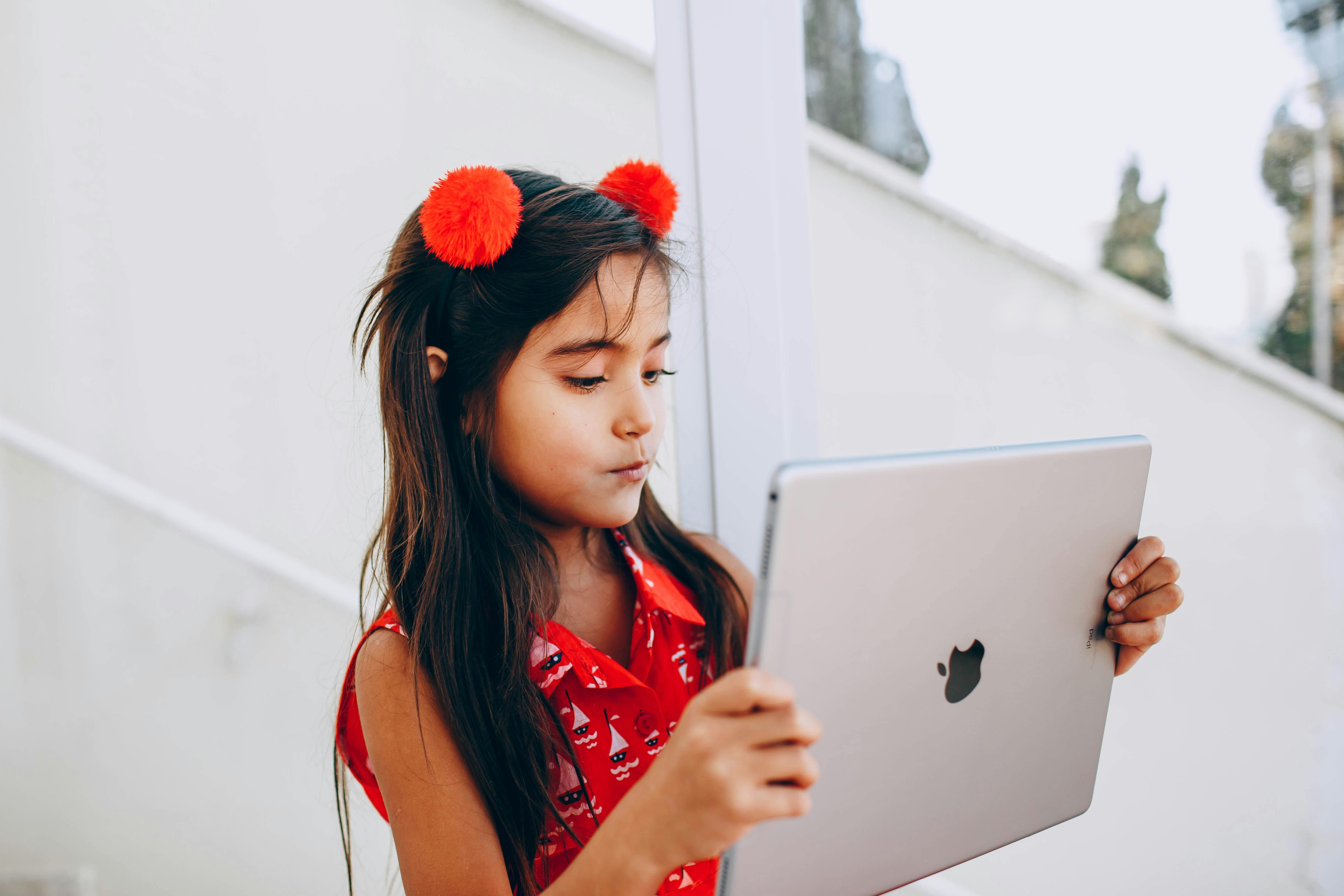 Young student using a tablet for digital learning, representing how schools evaluate iPads and Chromebooks as instructional devices for different grade levels and learning needs.