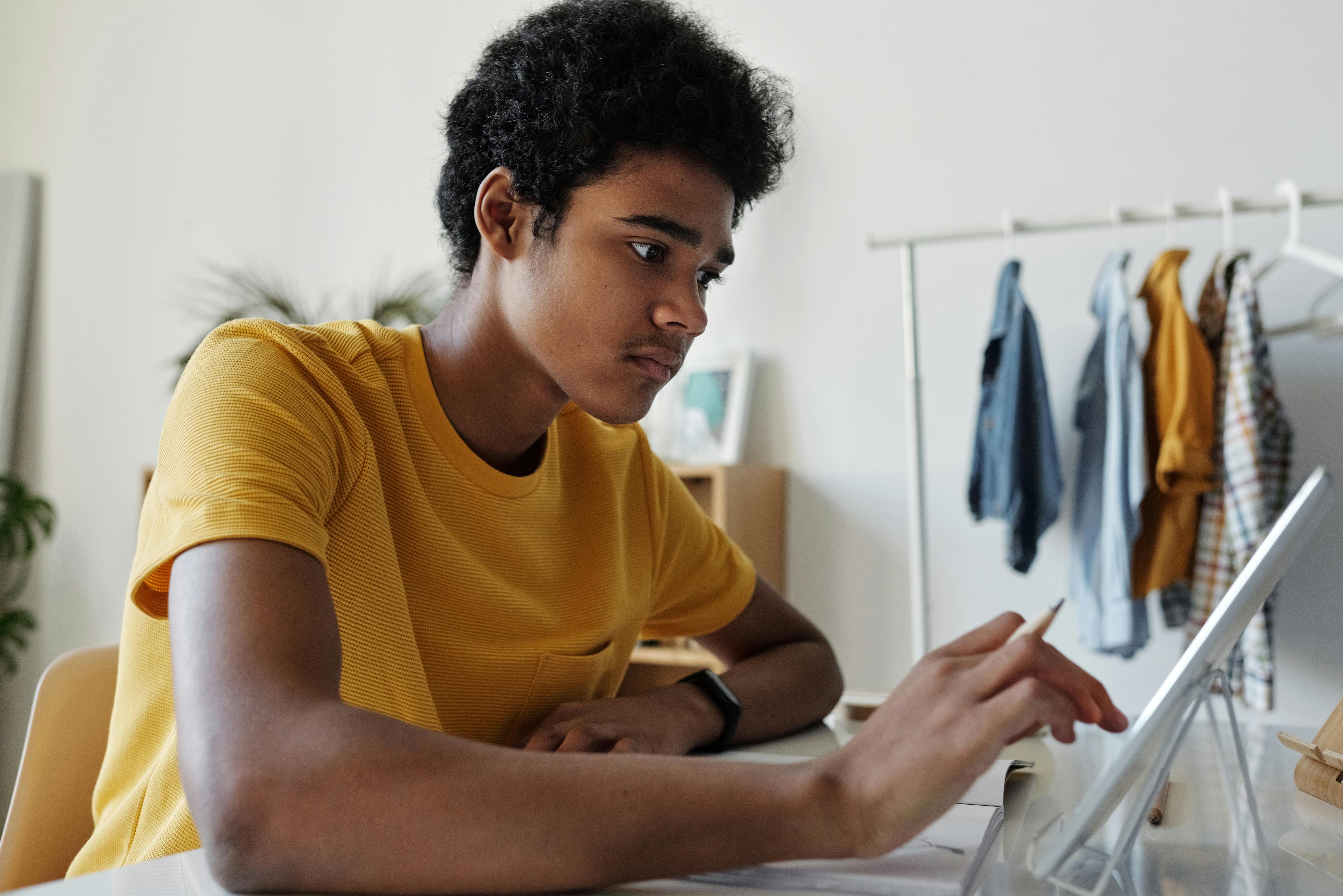 Student focused on schoolwork while using a tablet at a desk, representing how reliable classroom devices support uninterrupted learning and digital instruction in modern education.
